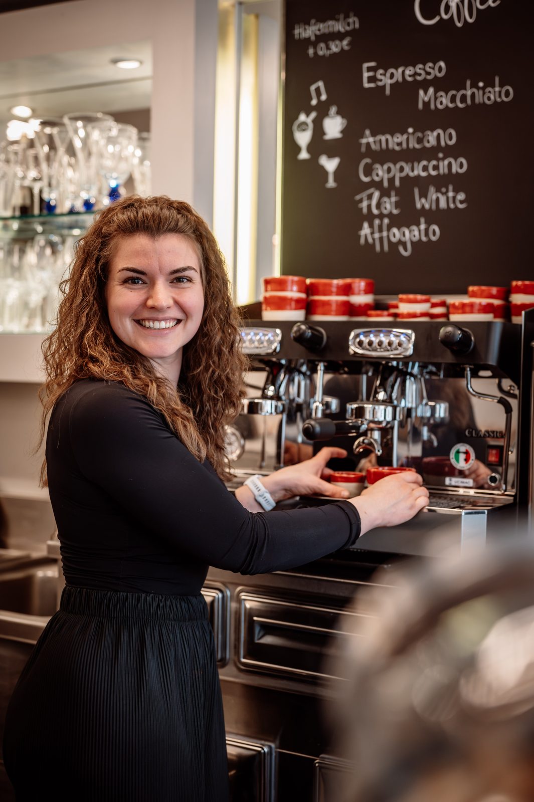 Franzi lächelt an der Espressomaschine im Francesca's